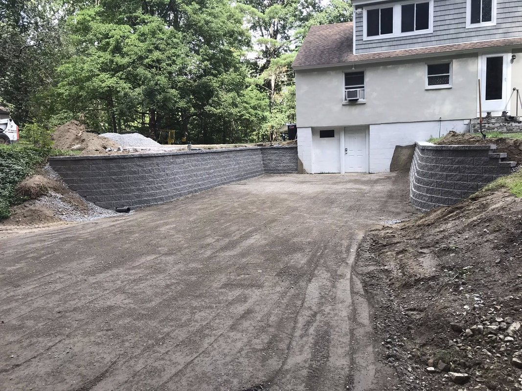 Completed block retaining wall with graded parking area - After